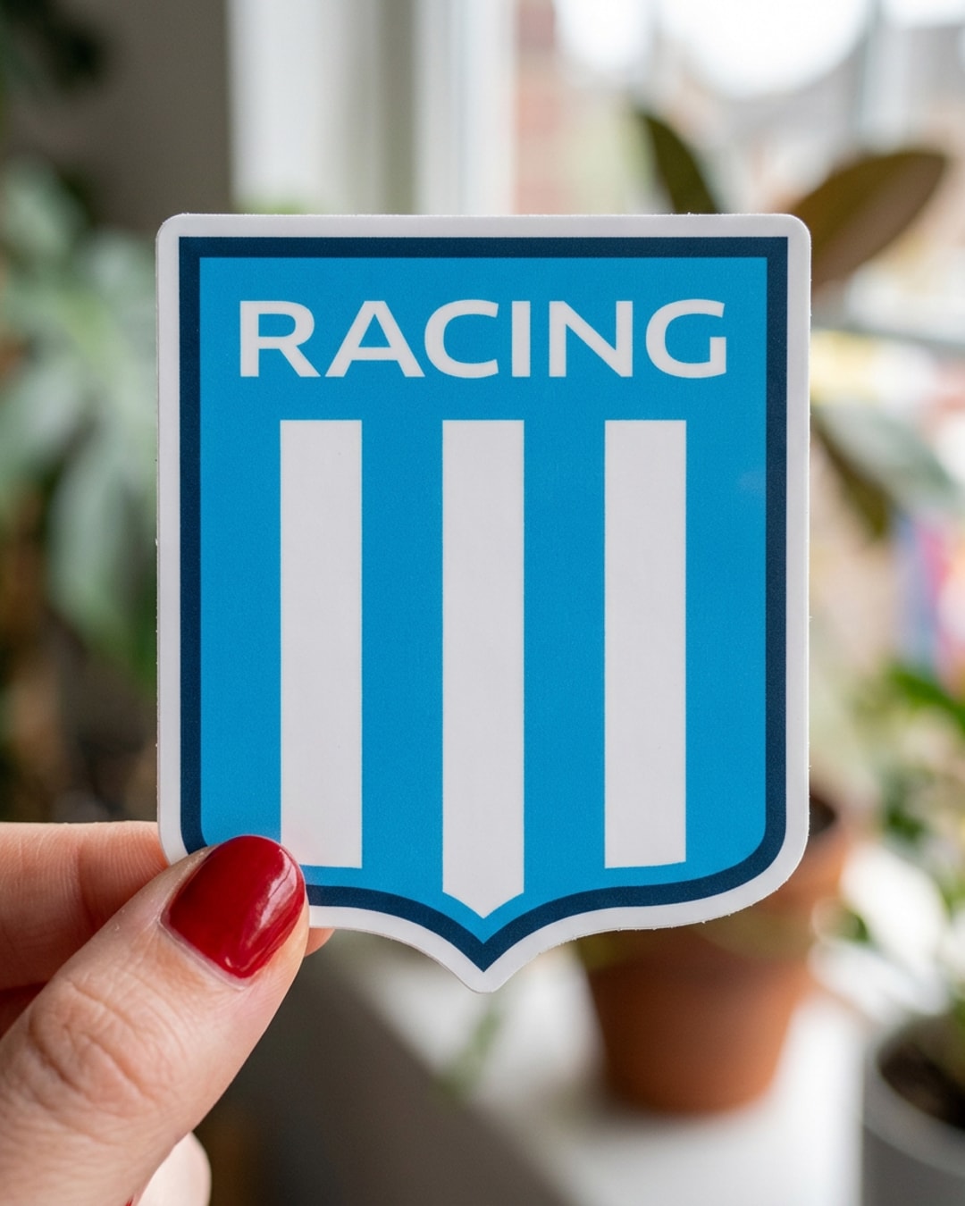 Pegatina Escudo de Racing Club sostenida en la mano, a tamaño real