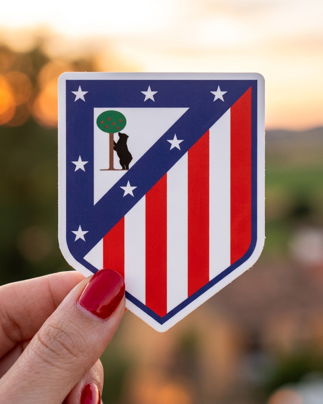 Pegatina Escudo de Atlético de Madrid sostenida en la mano, a tamaño real
