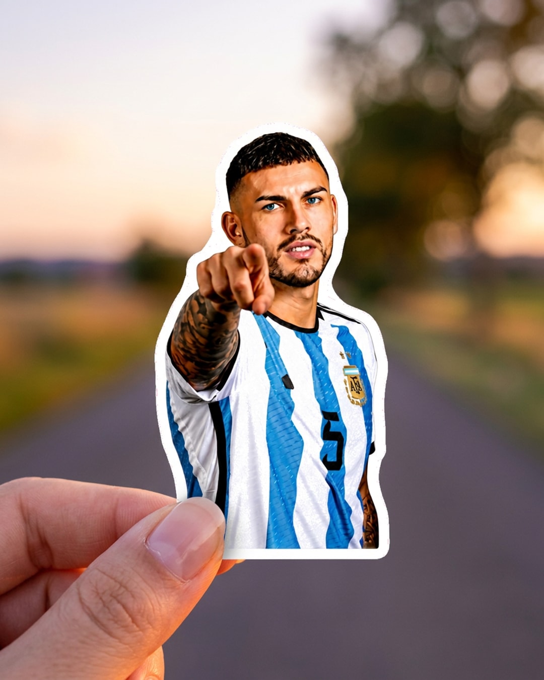 Pegatina Paredes señalando con camiseta de Argentina sostenida en la mano, a tamaño real