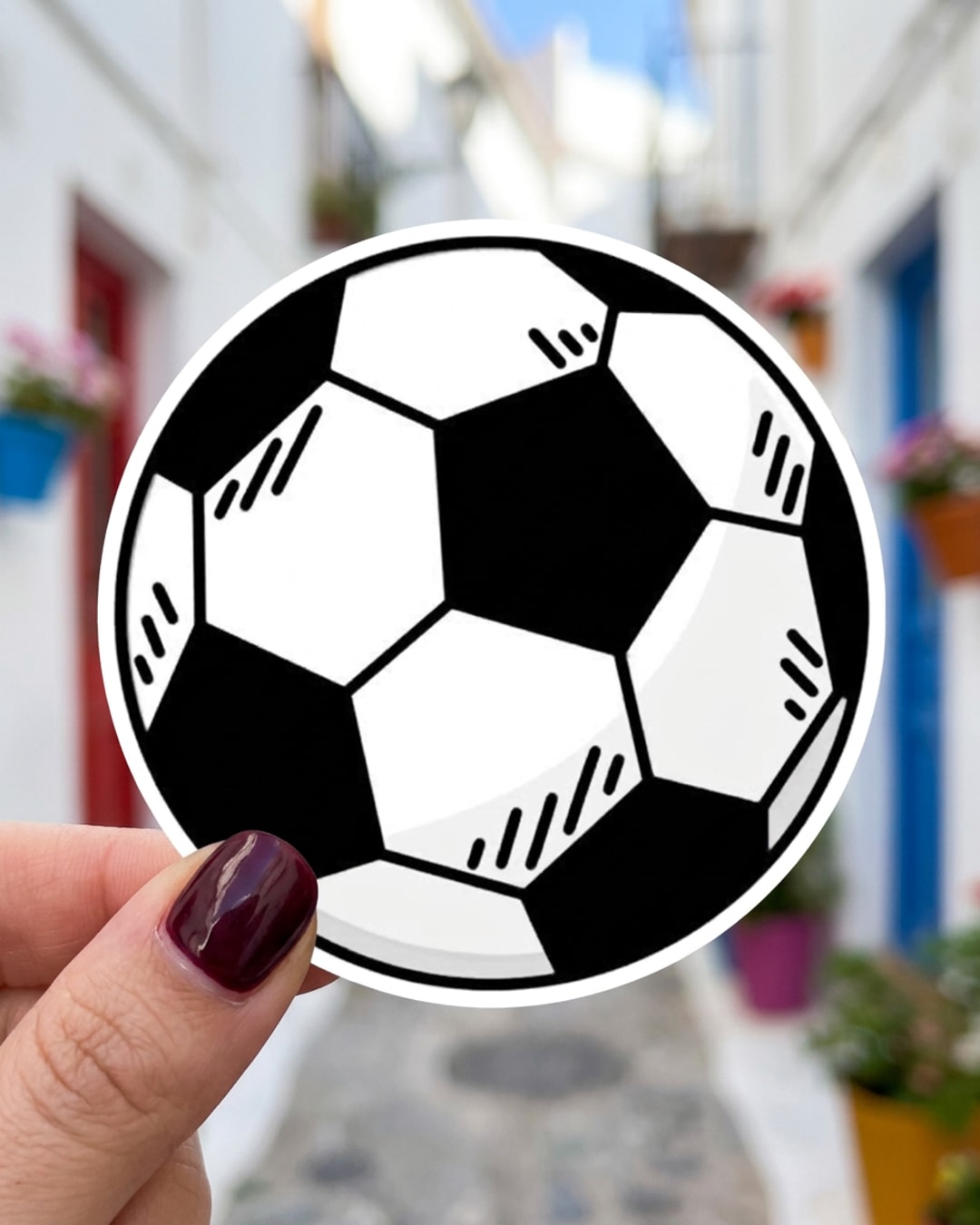 Pegatina Balón de fútbol clásico sostenida en la mano, a tamaño real
