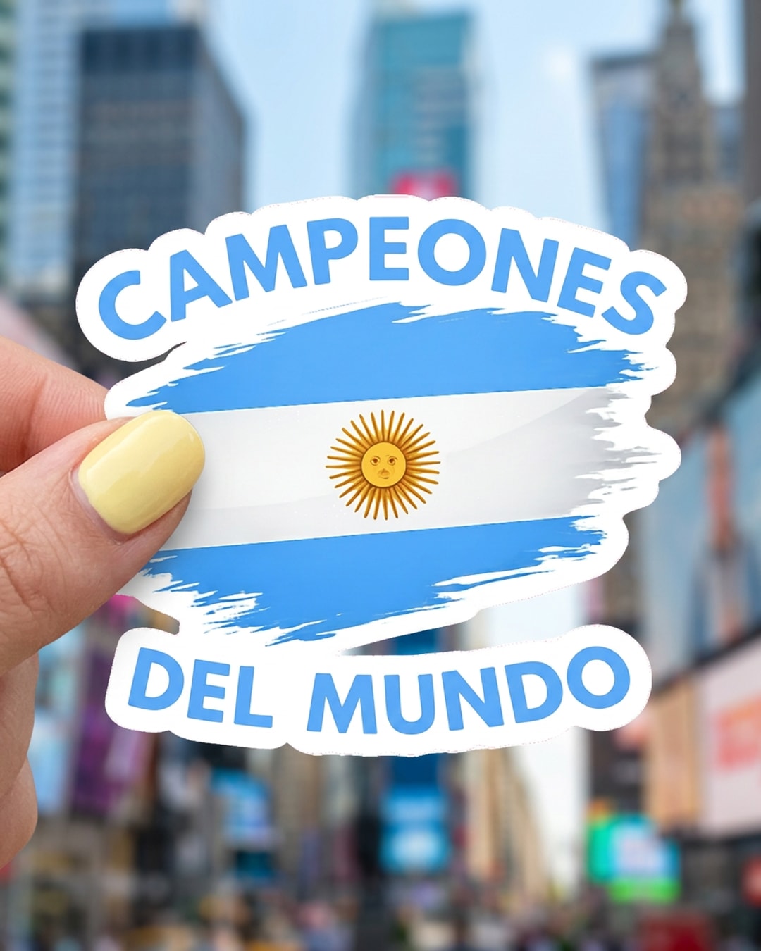 Pegatina Bandera de Argentina Campeones del Mundo sostenida en la mano, a tamaño real