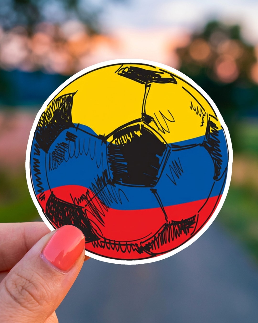 Pegatina Balón de Fútbol con Bandera de Colombia sostenida en la mano, a tamaño real