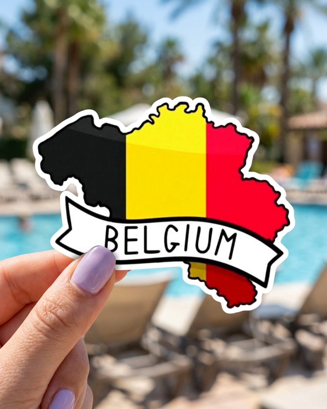 Pegatina Mapa de Bélgica con Bandera y Texto Belgium sostenida en la mano, a tamaño real