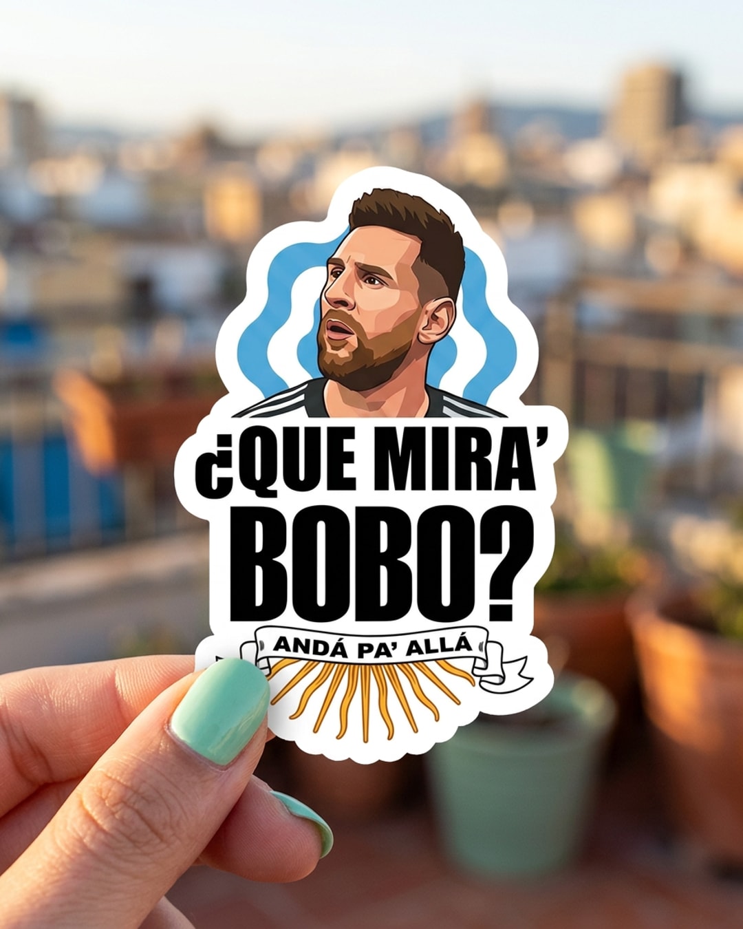 Pegatina Messi con la frase Qué Mirá Bobo sostenida en la mano, a tamaño real