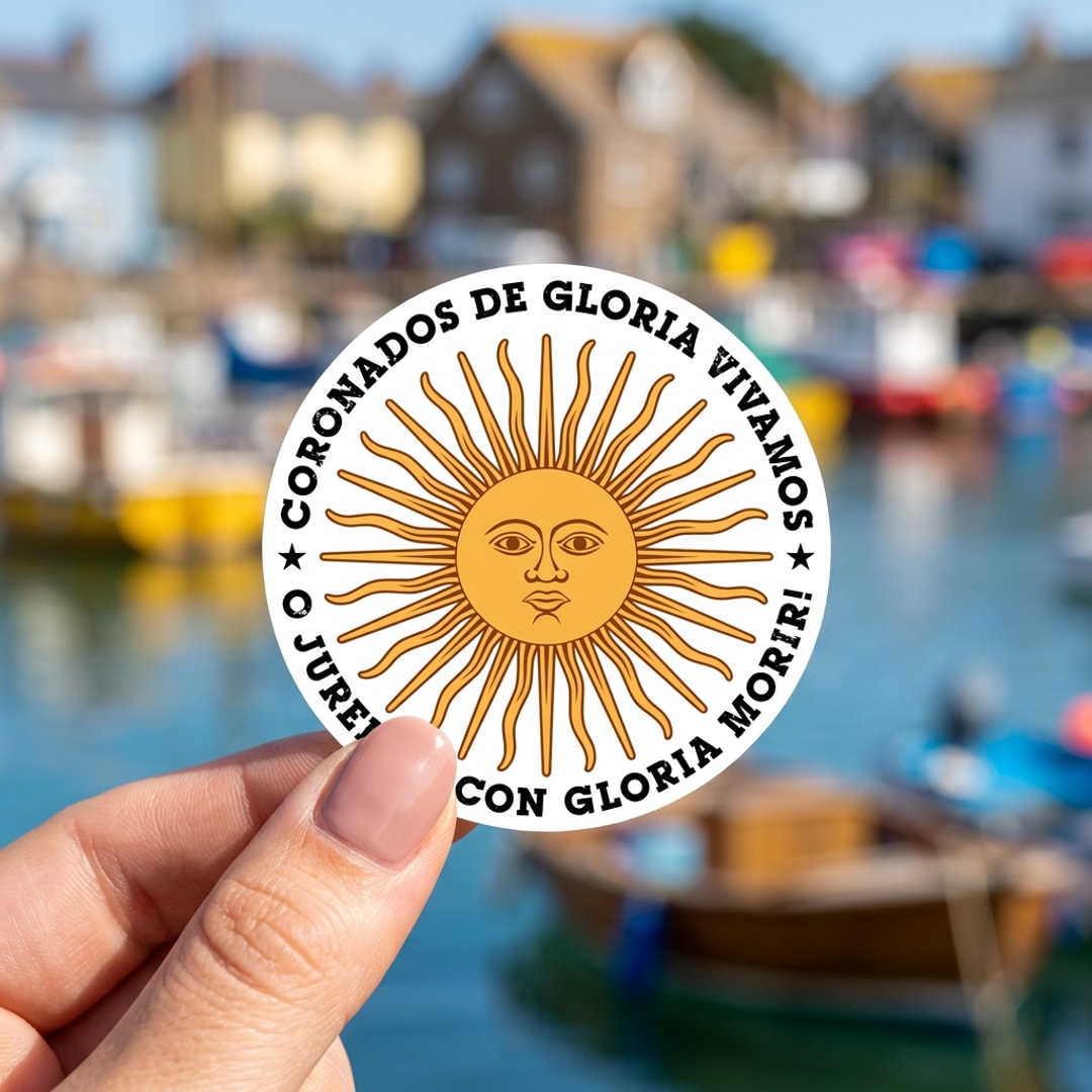 Pegatina Sol de Mayo con frase Coronados de Gloria sostenida en la mano, a tamaño real