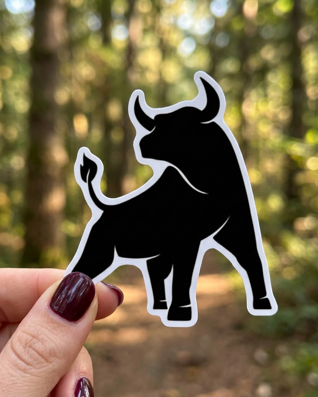 Pegatina Silueta de Toro Negro sostenida en la mano, a tamaño real