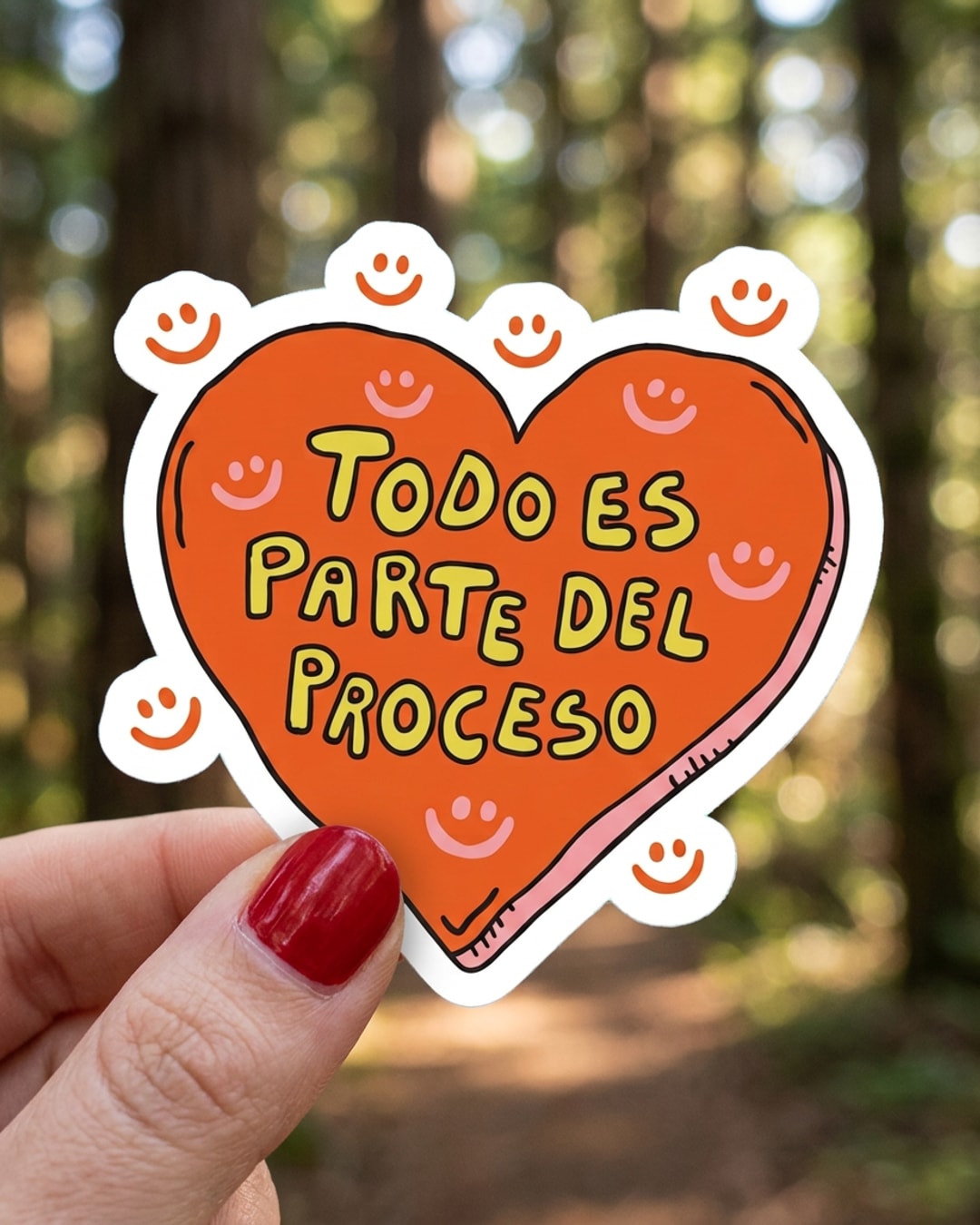Pegatina Corazón Naranja Todo es Parte del Proceso sostenida en la mano, a tamaño real