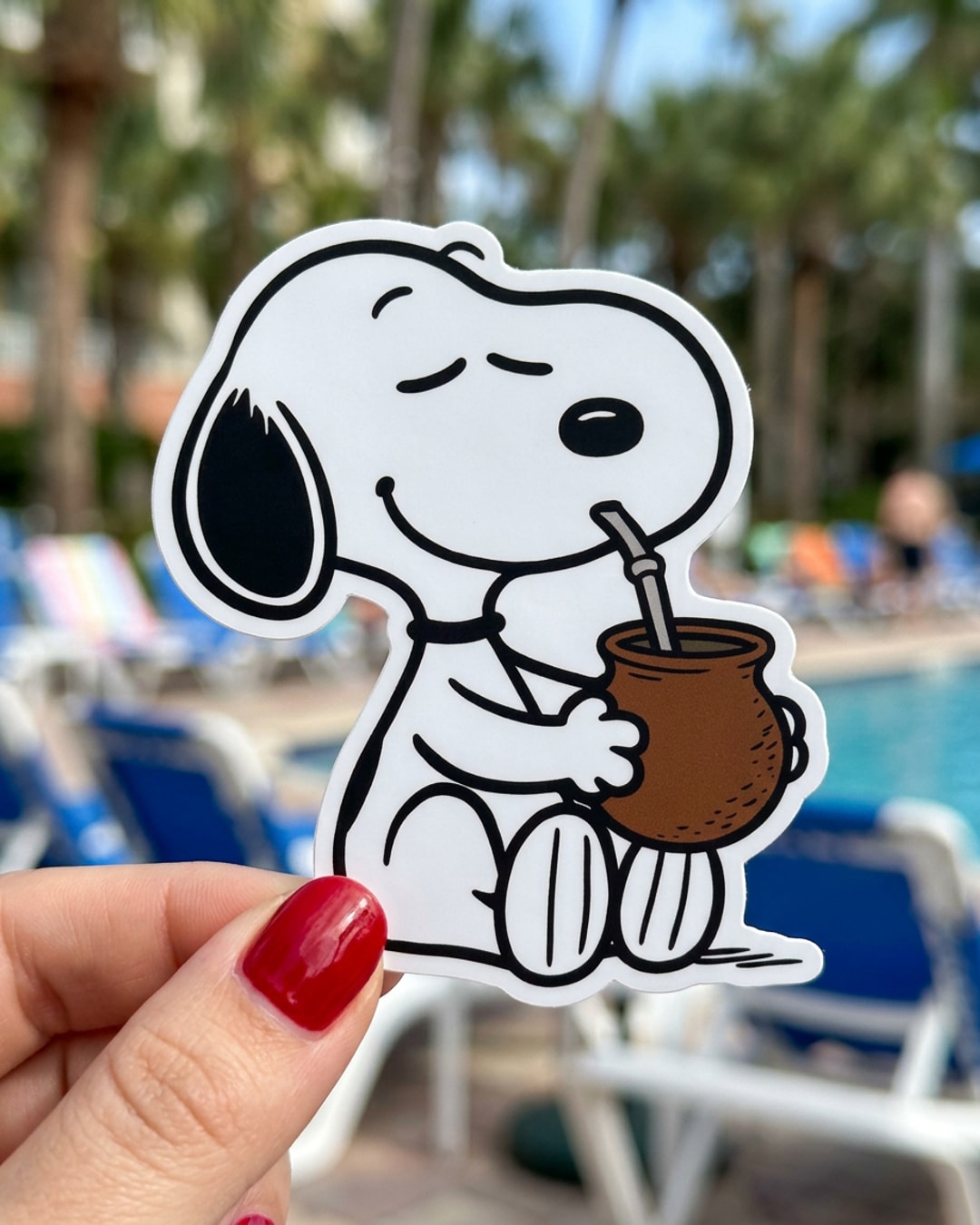 Pegatina Snoopy tomando mate sostenida en la mano, a tamaño real