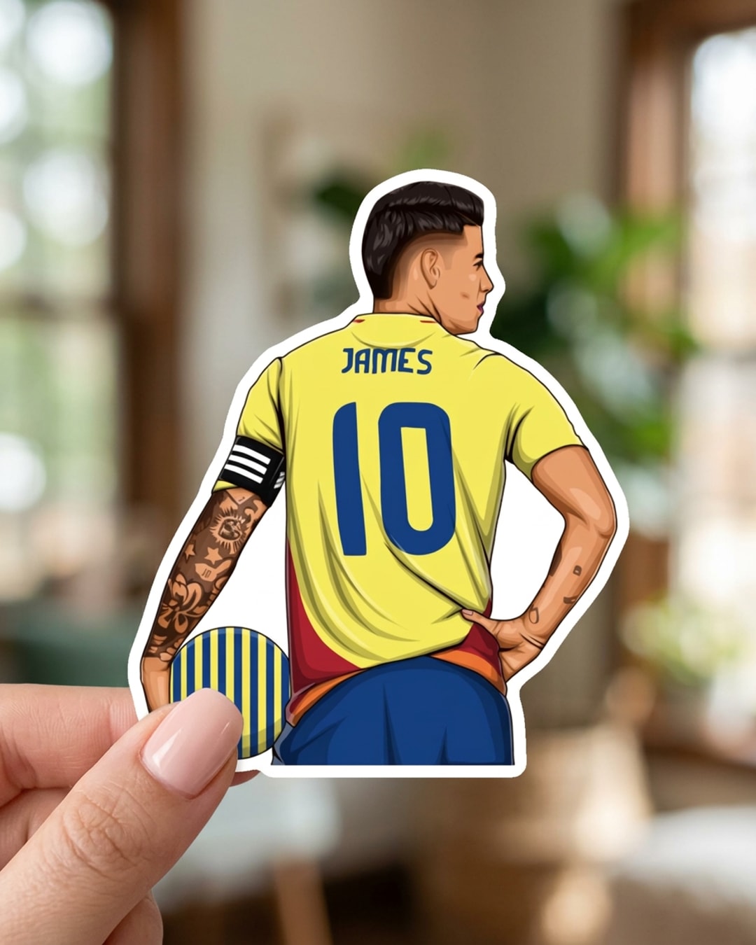 Pegatina James con el dorsal 10 de Colombia sostenida en la mano, a tamaño real