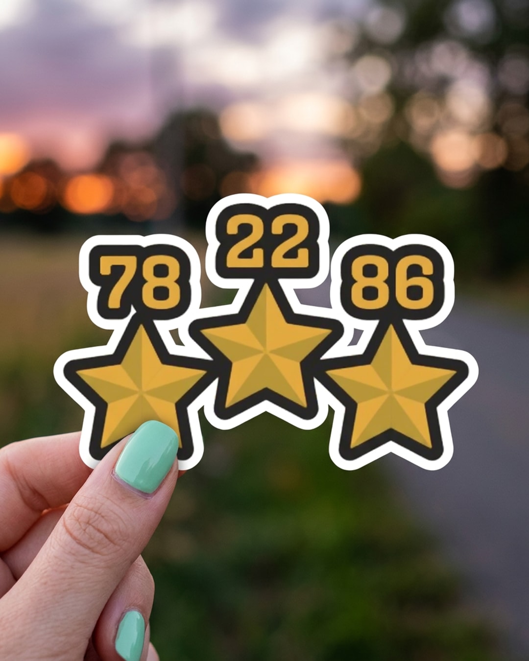 Pegatina Tres Estrellas de Argentina con Años 78 22 86 sostenida en la mano, a tamaño real