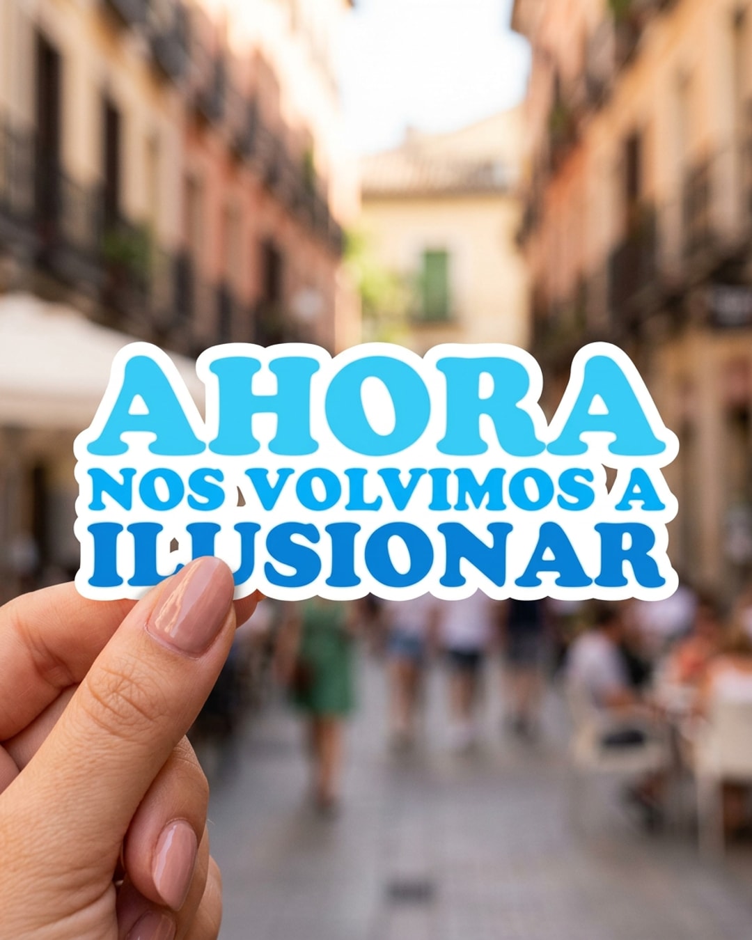Pegatina Ahora nos volvimos a ilusionar sostenida en la mano, a tamaño real
