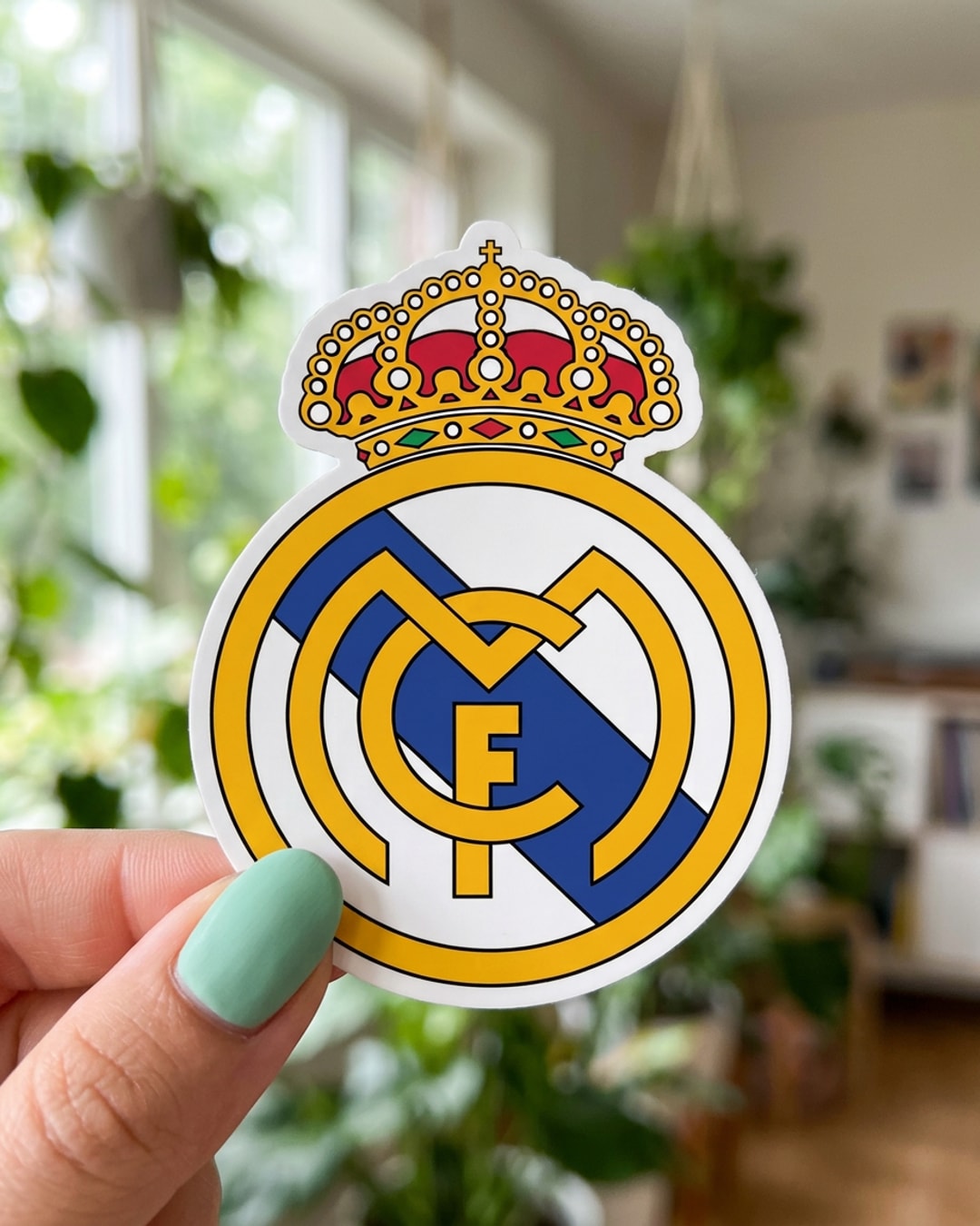 Pegatina Escudo Real Madrid sostenida en la mano, a tamaño real