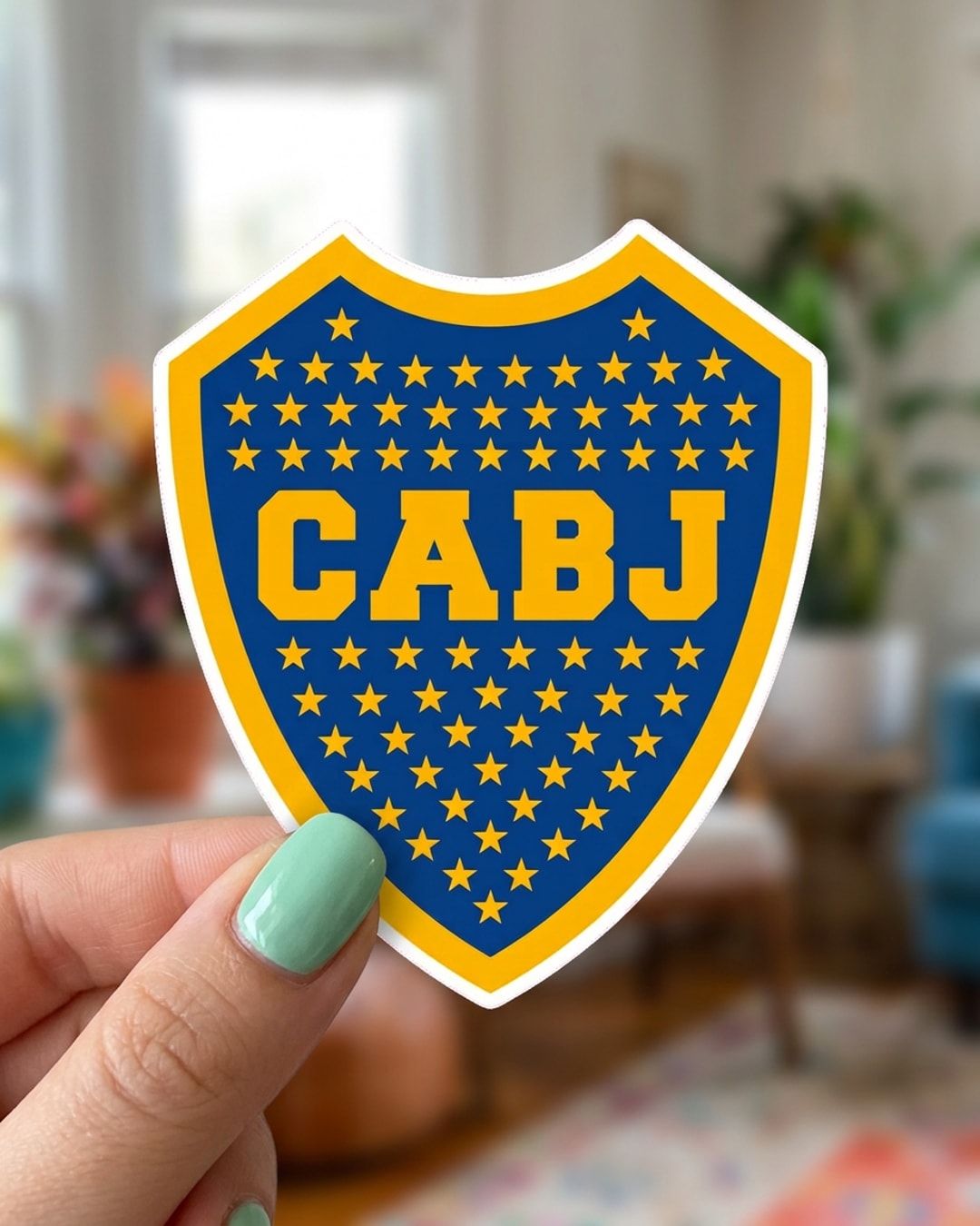 Pegatina Escudo de Boca Juniors CABJ sostenida en la mano, a tamaño real