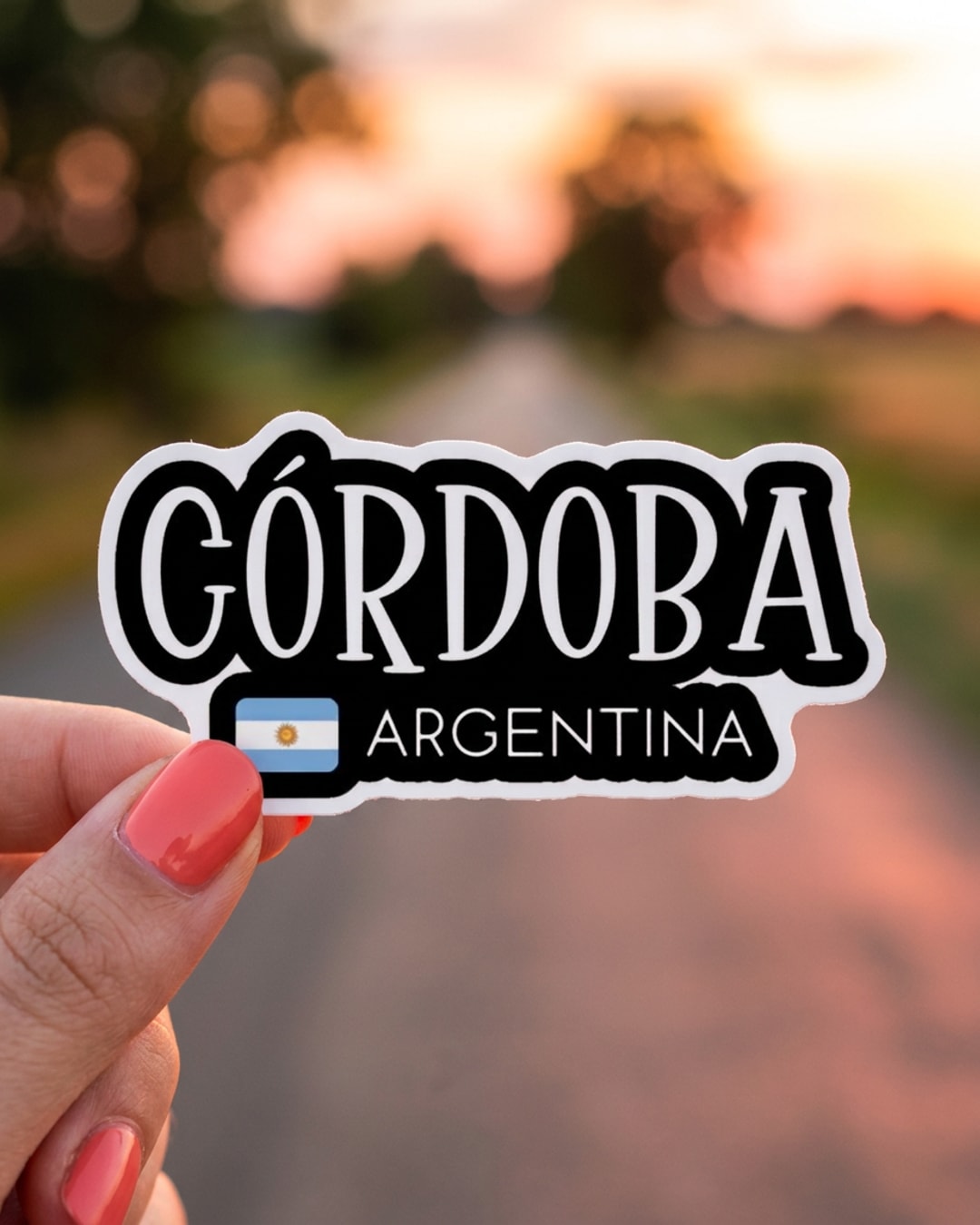 Pegatina Córdoba Argentina con bandera sostenida en la mano, a tamaño real