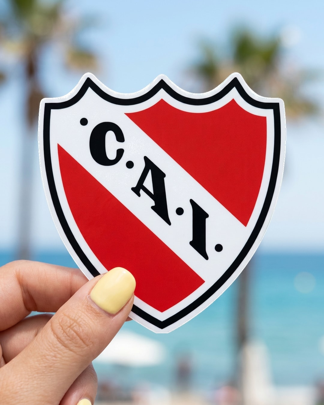 Pegatina Escudo de Independiente sostenida en la mano, a tamaño real