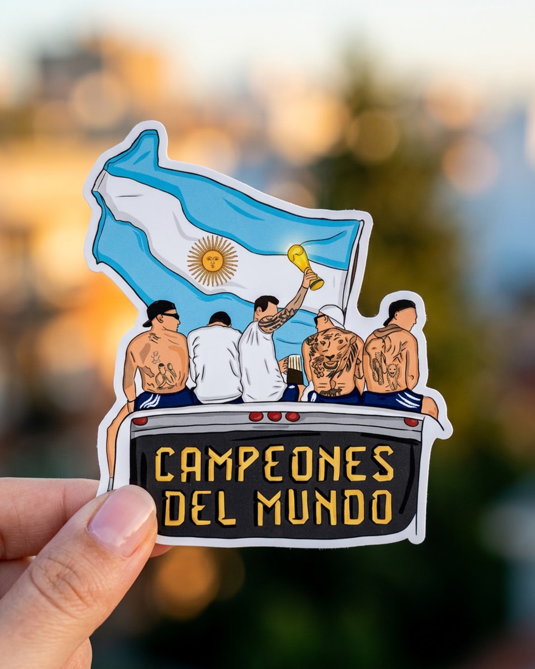 Pegatina Campeones del Mundo Seleccion Argentina sostenida en la mano, a tamaño real